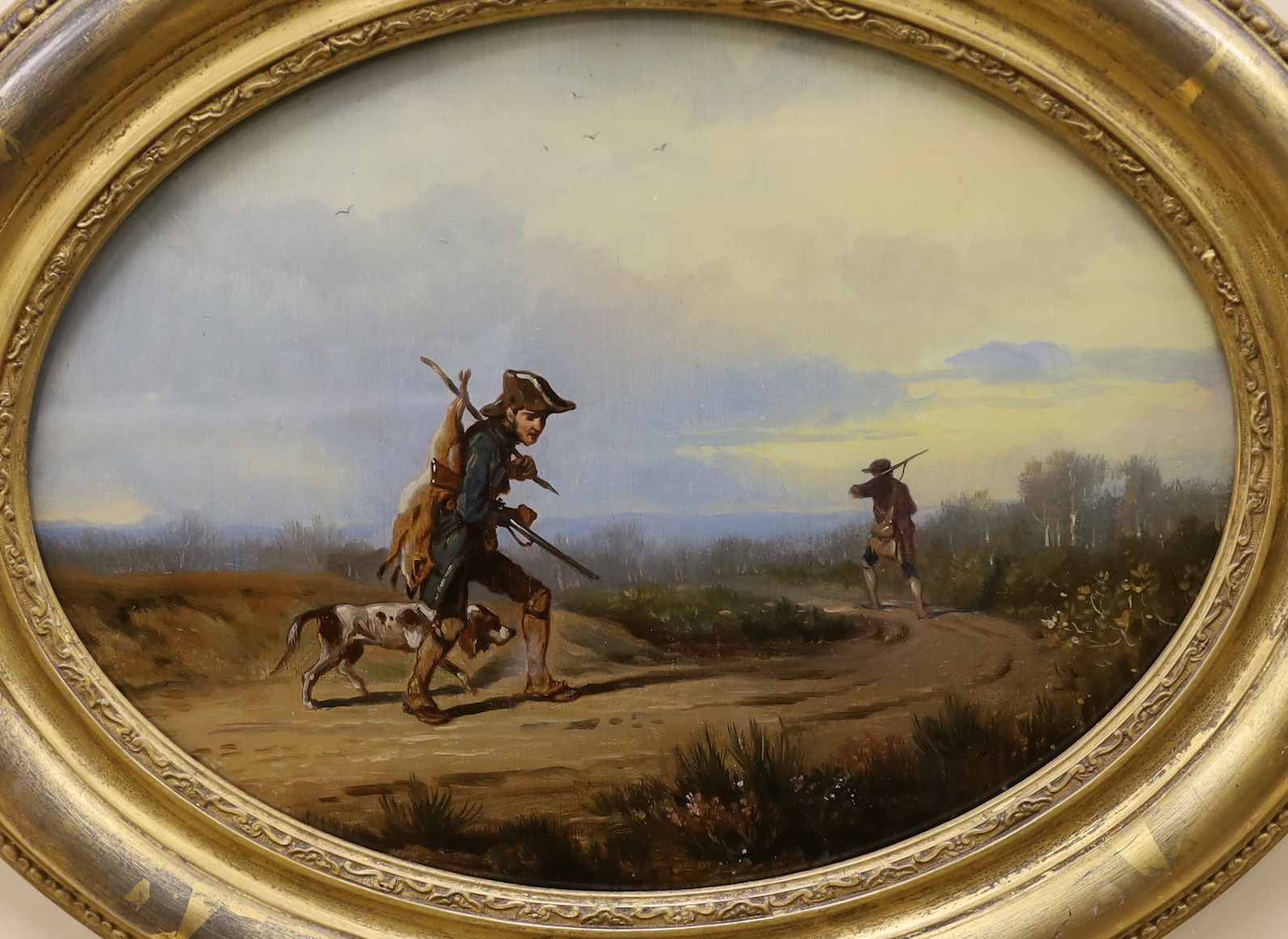 A pair of 19th century reverse painted oval framed sporting scenes, figures shooting along a pathway, 23 x 31cm